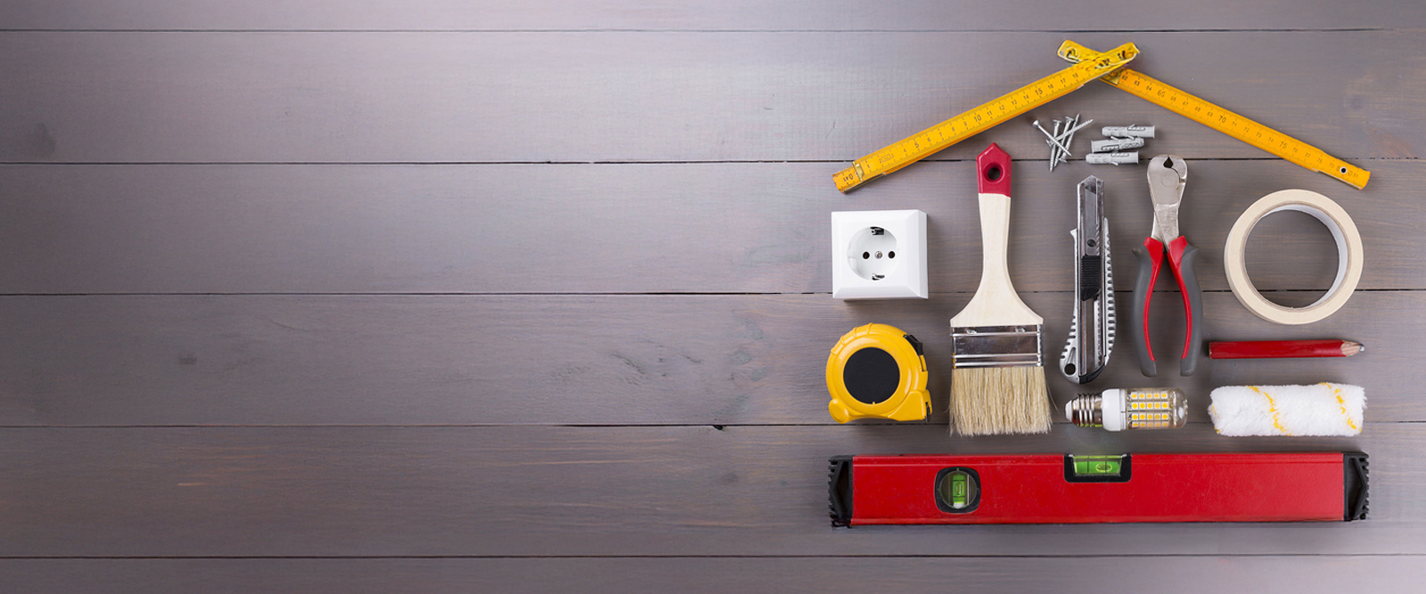 An assortment of contractor tools arranged in the shape of a house.
