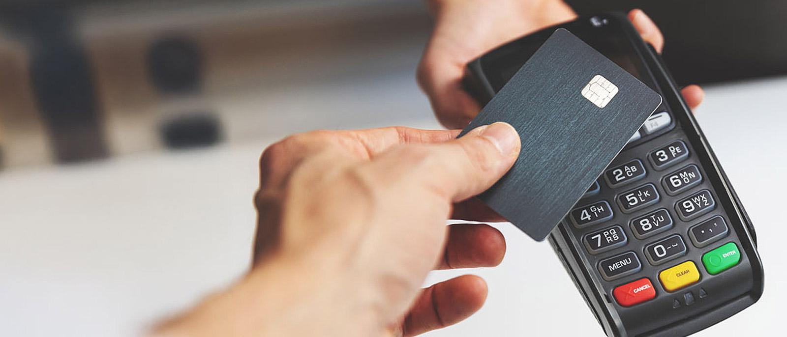 Person tapping debit card on a card terminal.