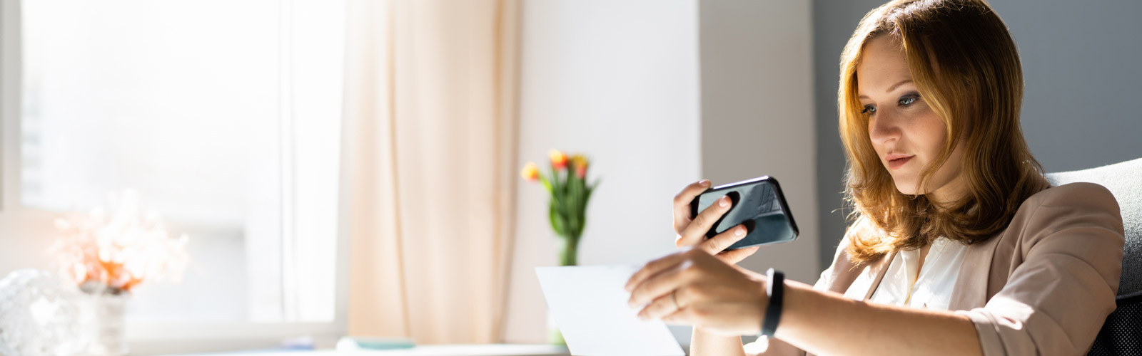 Woman taking a photo of a check with phone.