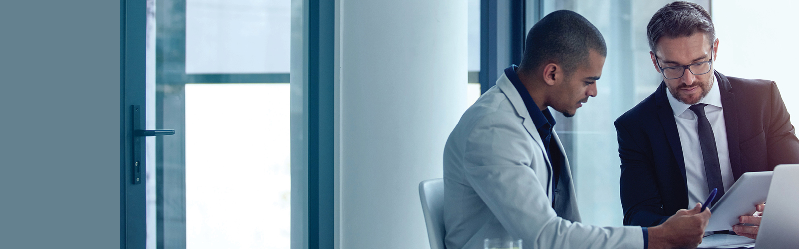 Two men in an office going over financial figures on a page.