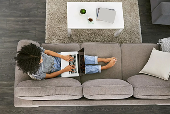 Person sitting on couch using laptop for online banking