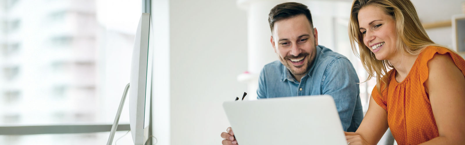 Photo of a happy couple doing banking on laptop.