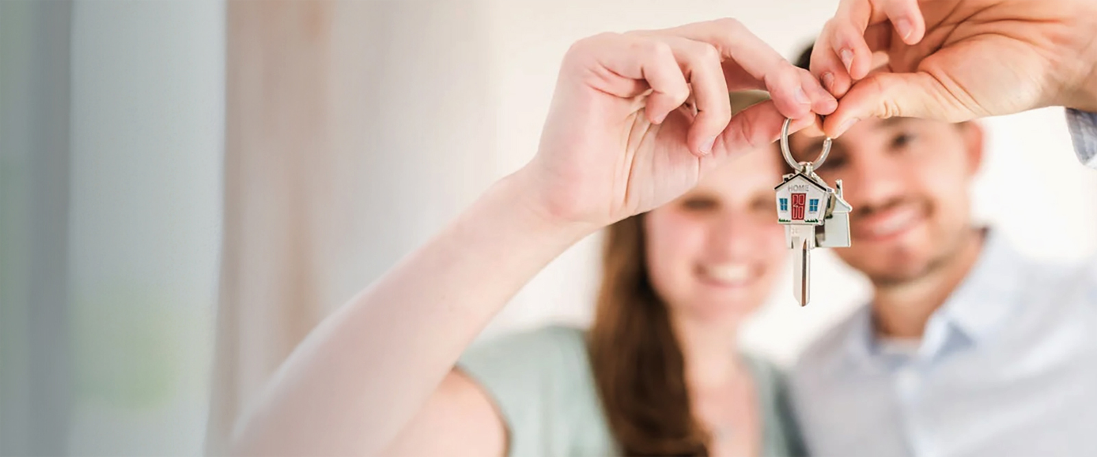 Happy young couple holding the keys to their new home.