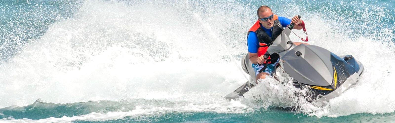 Man riding a jet ski on the water on a bright sunny day.